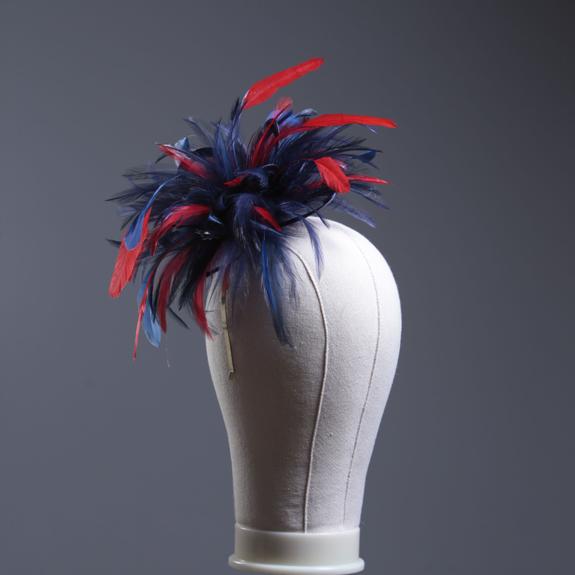 navy blue and red small hackle fascinator hat with feathers set on a headband